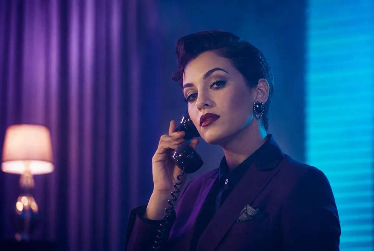 Glamouröse Person mit elegantem Make-up am Telefon, Violett-Cyan-Licht